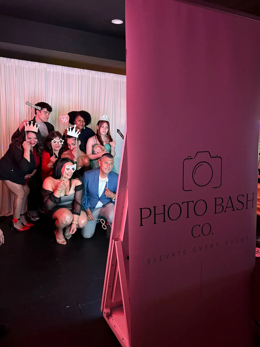 Guests posing with props at a PhotoBash Sweet 16 celebration
