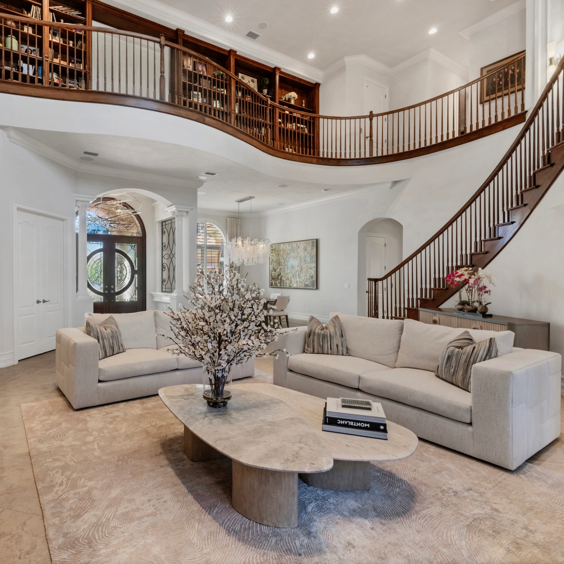 MMinteriors grand foyer with curved staircase and bespoke furnishings
